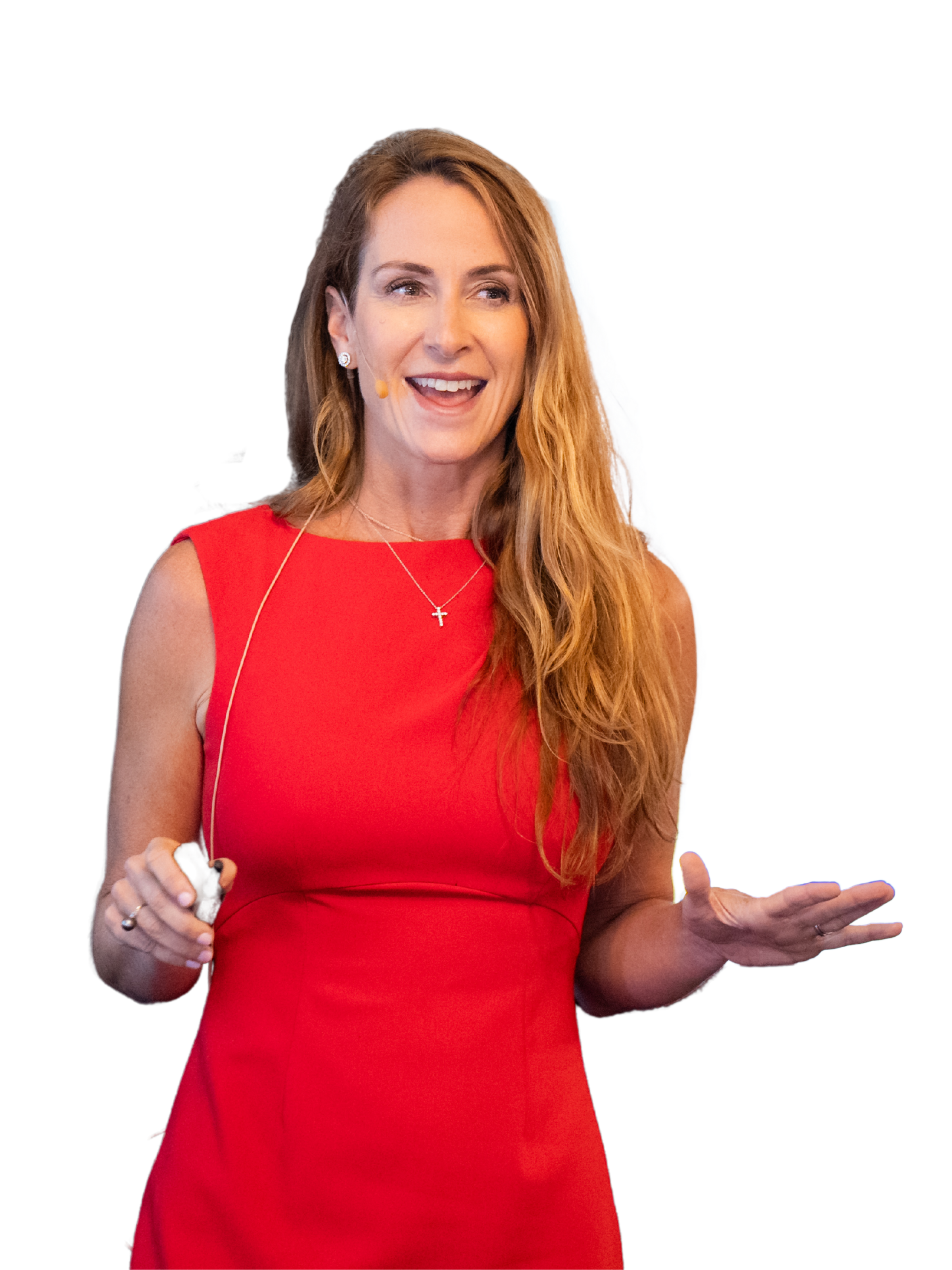 A woman with long red hair, wearing a red sleeveless dress, smiling and gesturing while holding a remote control.
